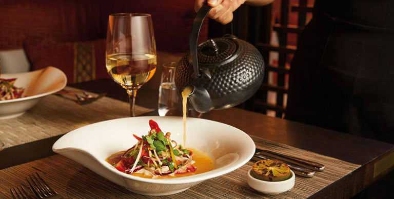 Consommé being poured onto food